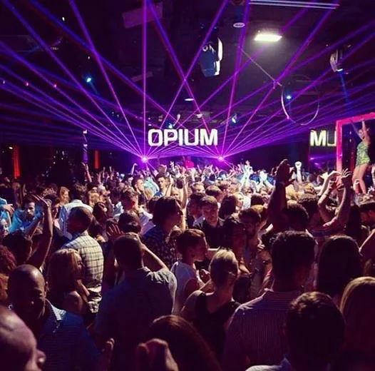 Pista de Opium Barcelona llena bajo el rótulo luminoso y los láseres